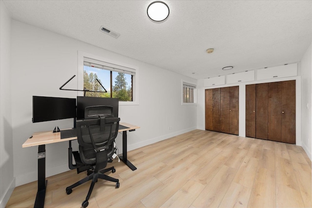 office area with wood finished floors, baseboards, and a textured ceiling