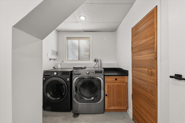 laundry room featuring cabinet space, washer and clothes dryer, and light tile patterned floors