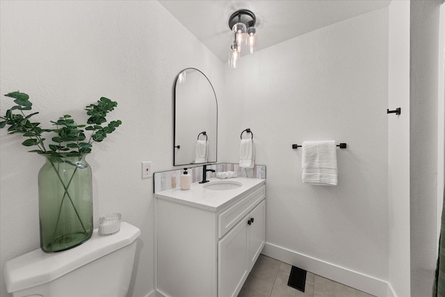 bathroom with vanity, toilet, tile patterned floors, and baseboards