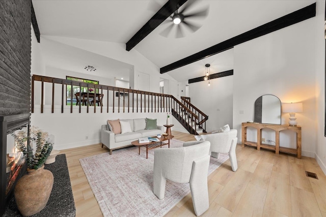 living area with light wood-style flooring, a ceiling fan, stairway, and baseboards