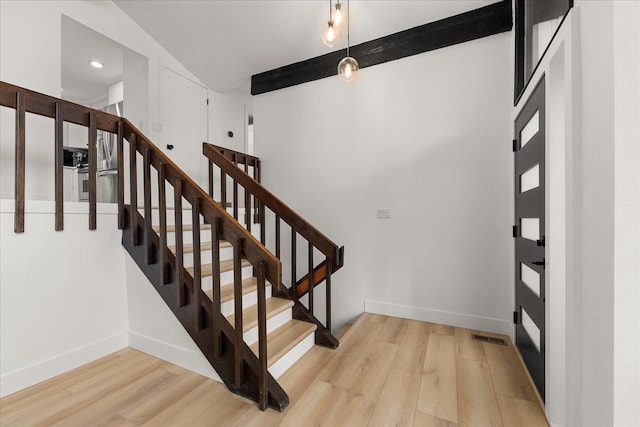 stairs featuring wood finished floors, baseboards, beam ceiling, and recessed lighting