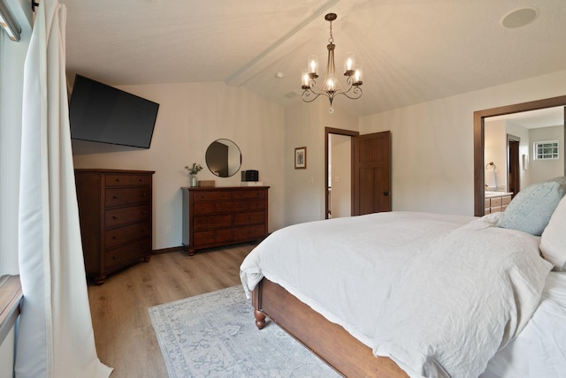 bedroom with light wood-style floors, a chandelier, ensuite bath, and baseboards