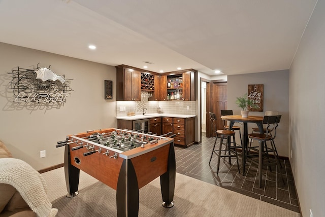 recreation room featuring bar with sink, recessed lighting, baseboards, and wine cooler