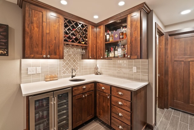 indoor wet bar featuring beverage cooler, backsplash, and wood tiled floors