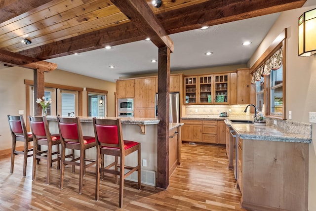 4224 E Hoffman Ln, Spokane, WA 99223 - kitchen featuring a sink, light wood finished floors, beam ceiling, appliances with stainless steel finishes, and tasteful backsplash