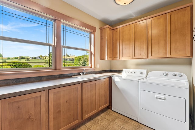 4224 E Hoffman Ln, Spokane, WA 99223 - laundry area featuring cabinet space, washer and clothes dryer, and light tile patterned flooring
