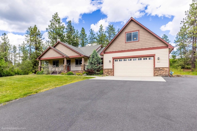 craftsman-style house with stone siding, asphalt driveway, covered porch, and a front lawn