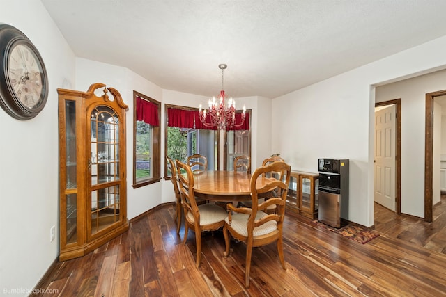 dining area with a chandelier, dark wood-style flooring, and baseboards