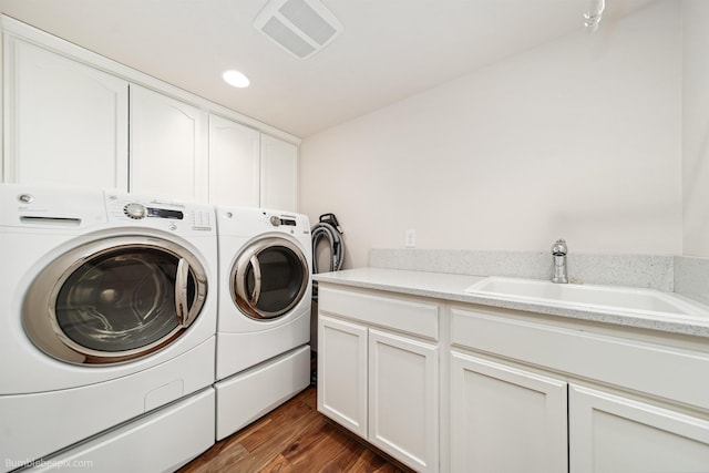 laundry room with washer and clothes dryer, cabinet space, dark wood-type flooring, and recessed lighting