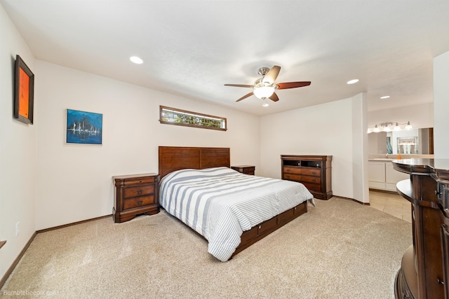 bedroom featuring light colored carpet, recessed lighting, baseboards, ensuite bath, and a ceiling fan