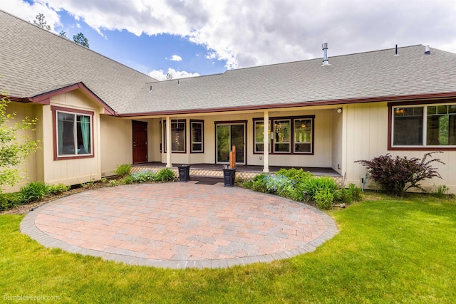 rear view of house with a yard and a shingled roof