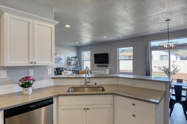 14621 E Sanson Ave, Spokane Valley, WA 99216 - kitchen featuring a sink, stainless steel dishwasher, a textured ceiling, healthy amount of natural light, and white cabinets