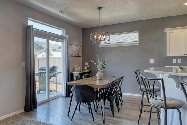 14621 E Sanson Ave, Spokane Valley, WA 99216 - dining area with a textured ceiling, a chandelier, light wood-style flooring, and baseboards