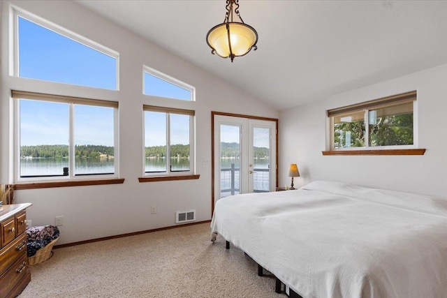 bedroom with access to outside, multiple windows, lofted ceiling, and a water view