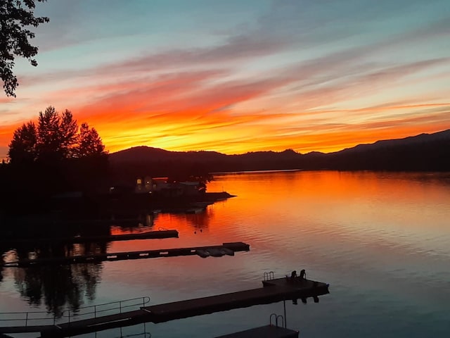 water view with a mountain backdrop and a boat dock