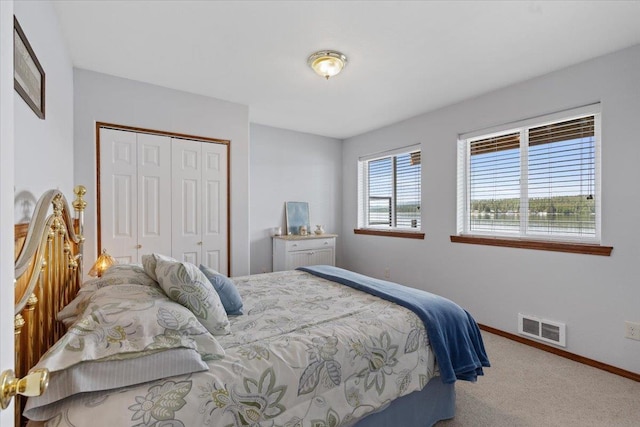 carpeted bedroom with a closet and baseboards