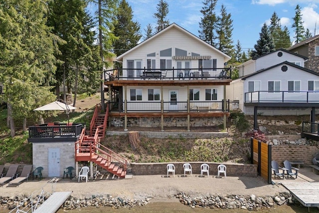 rear view of house featuring stairs and a deck