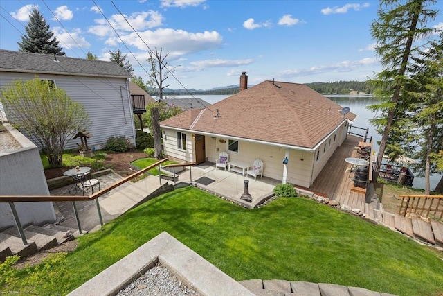 back of house featuring a water view and a patio area