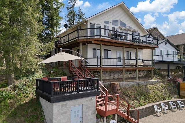 rear view of house featuring stairway and a deck