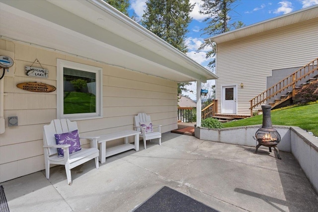 view of patio with an outdoor fire pit and stairway