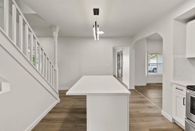13704 E Heroy Ave, Spokane Valley, WA 99216 - kitchen featuring white cabinets, a kitchen island, light countertops, and arched walkways