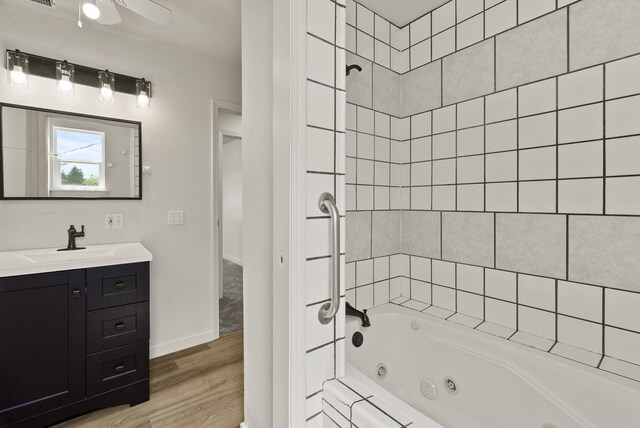 13704 E Heroy Ave, Spokane Valley, WA 99216 - bathroom with wood finished floors, a combined bath / shower with jetted tub, baseboards, vanity, and ceiling fan