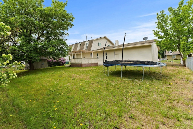 13704 E Heroy Ave, Spokane Valley, WA 99216 - back of property with a trampoline, a storage shed, a deck, an outdoor structure, and a lawn
