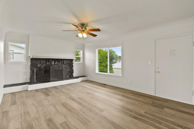 13704 E Heroy Ave, Spokane Valley, WA 99216 - unfurnished living room featuring ceiling fan, a stone fireplace, wood finished floors, and baseboards