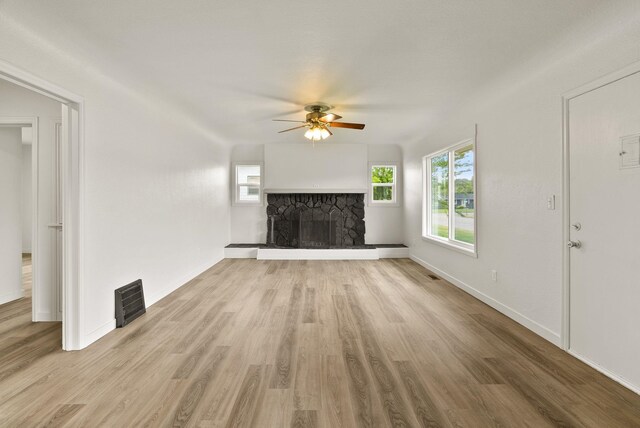 13704 E Heroy Ave, Spokane Valley, WA 99216 - unfurnished living room featuring ceiling fan, a stone fireplace, wood finished floors, and baseboards