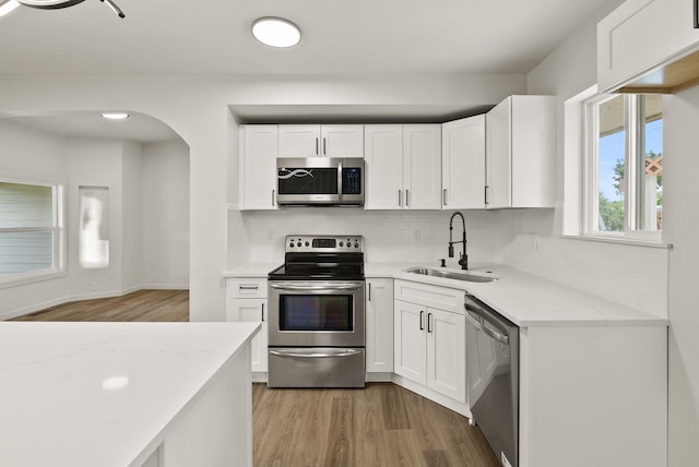 13704 E Heroy Ave, Spokane Valley, WA 99216 - kitchen featuring stainless steel appliances, a sink, light wood-style flooring, and decorative backsplash