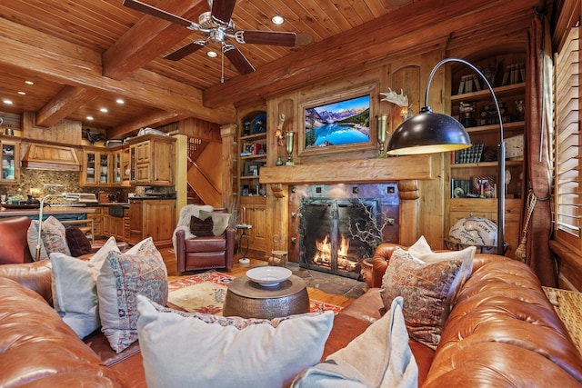 10351 N Gibson Rd, Hayden, ID 83835 - living room with wood ceiling, a premium fireplace, wood finished floors, beam ceiling, and a ceiling fan