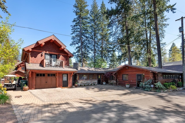 10351 N Gibson Rd, Hayden, ID 83835 - log cabin with a balcony, decorative driveway, and a garage