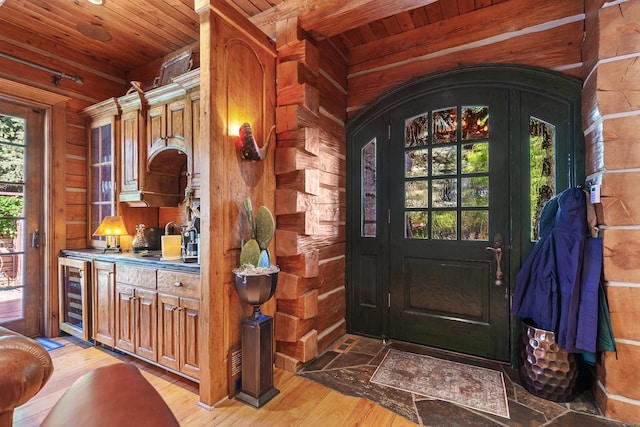 10351 N Gibson Rd, Hayden, ID 83835 - entryway with wooden ceiling, wood walls, beverage cooler, and light wood-type flooring