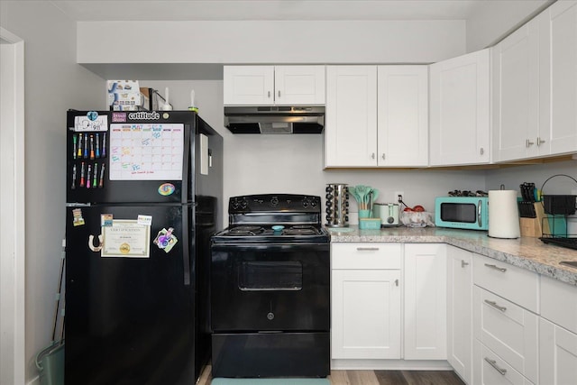 11707 E Broadway Ave, Spokane, WA 99206 - kitchen featuring black appliances, under cabinet range hood, white cabinets, wood finished floors, and light stone counters