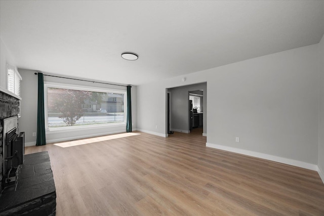 11707 E Broadway Ave, Spokane, WA 99206 - unfurnished living room with light wood-type flooring, healthy amount of natural light, and a fireplace