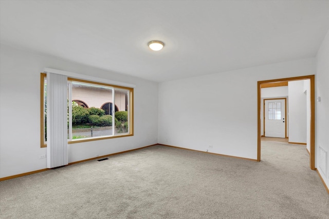 carpeted spare room featuring baseboards