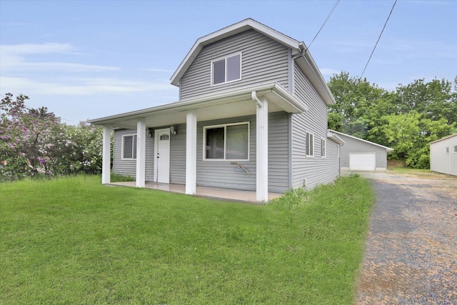 view of front of property featuring a porch, a front yard, and a garage