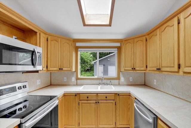 kitchen with appliances with stainless steel finishes, a sink, backsplash, and light countertops