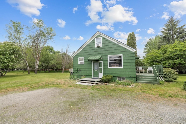 view of front of house with a front yard and a wooden deck