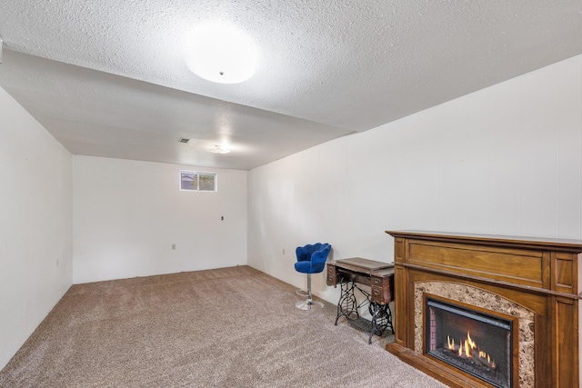 additional living space featuring carpet, a high end fireplace, and a textured ceiling