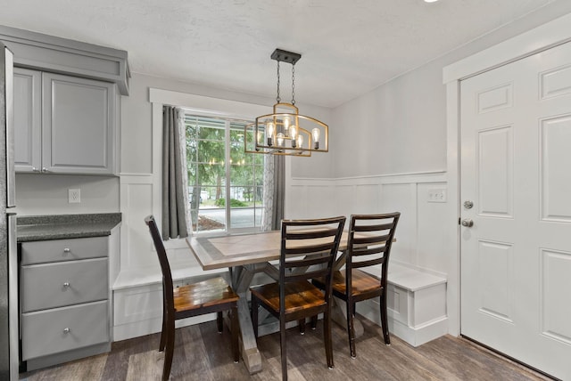 16814 N Tamarac Ln, Nine Mile Falls, WA 99026 - dining area featuring a chandelier, wood finished floors, a wainscoted wall, and a decorative wall