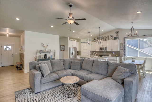 25523 N N Sheridan Rd, Chattaroy, WA 99003 - living room with vaulted ceiling, light wood finished floors, ceiling fan, a chandelier, and recessed lighting