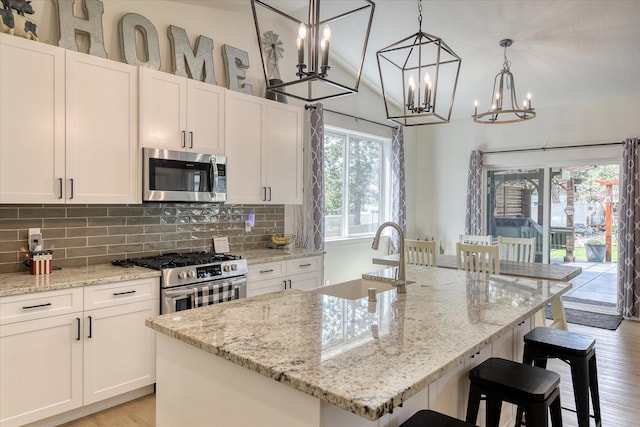 25523 N N Sheridan Rd, Chattaroy, WA 99003 - kitchen featuring stainless steel appliances, a sink, a chandelier, tasteful backsplash, and white cabinets