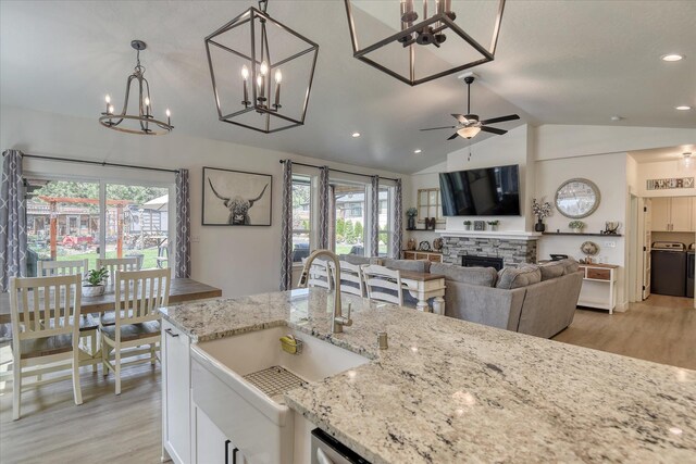 25523 N N Sheridan Rd, Chattaroy, WA 99003 - kitchen featuring a sink, light wood-type flooring, vaulted ceiling, a chandelier, and healthy amount of natural light