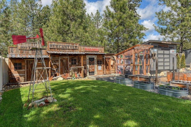 25523 N N Sheridan Rd, Chattaroy, WA 99003 - back of property featuring an outbuilding, a vegetable garden, metal roof, and an exterior structure