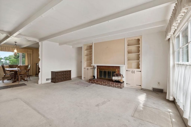 823 N Woodlawn Rd, Spokane Valley, WA 99216 - unfurnished living room with beam ceiling, carpet floors, a brick fireplace, built in shelves, and baseboards