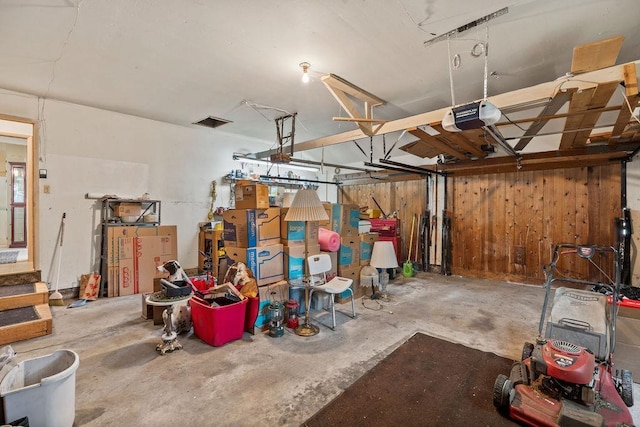 823 N Woodlawn Rd, Spokane Valley, WA 99216 - garage featuring a garage door opener and wooden walls