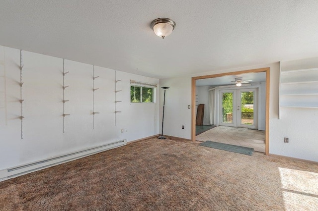 47 Davis Lake Ln, Usk, WA 99180 - carpeted spare room featuring a baseboard heating unit, french doors, healthy amount of natural light, a textured ceiling, and baseboards