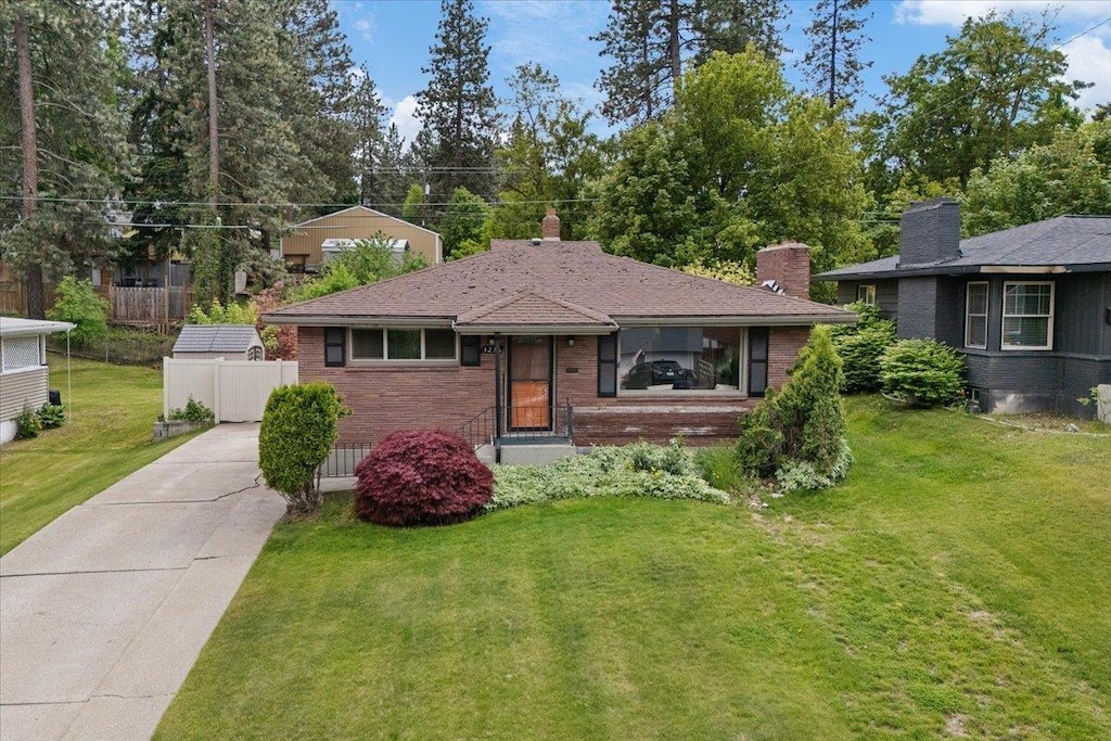 3236 E 16th Ave, Spokane, WA 99223 - view of front facade with brick siding, a chimney, and driveway