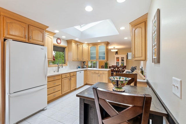 kitchen with white appliances, light brown cabinetry, a sink, backsplash, and recessed lighting